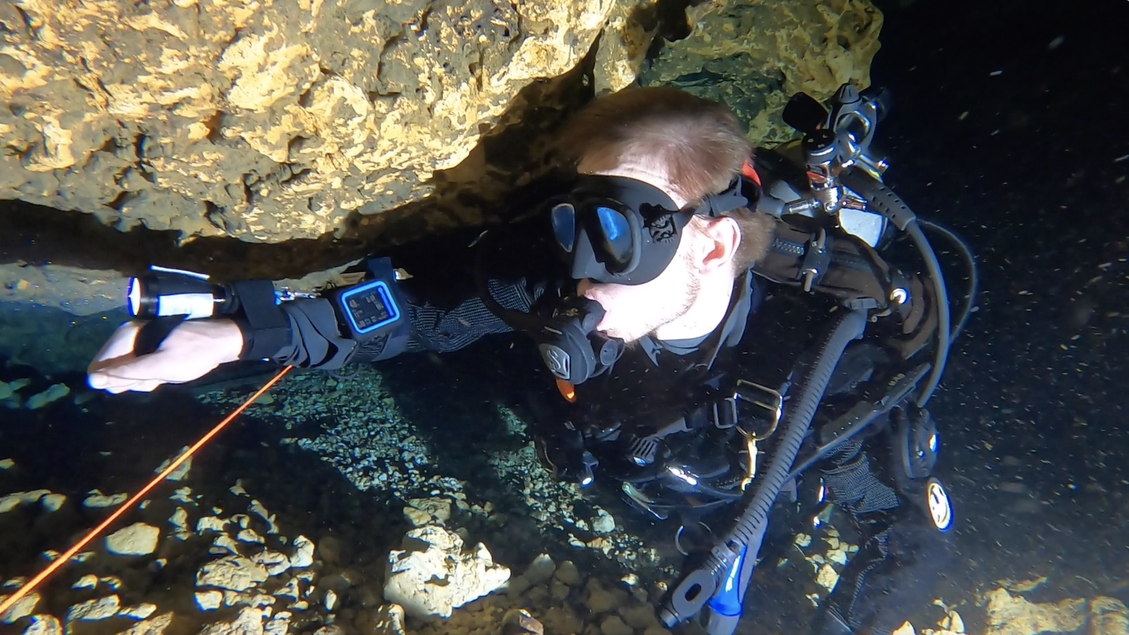 Diver shining his light in a cavern